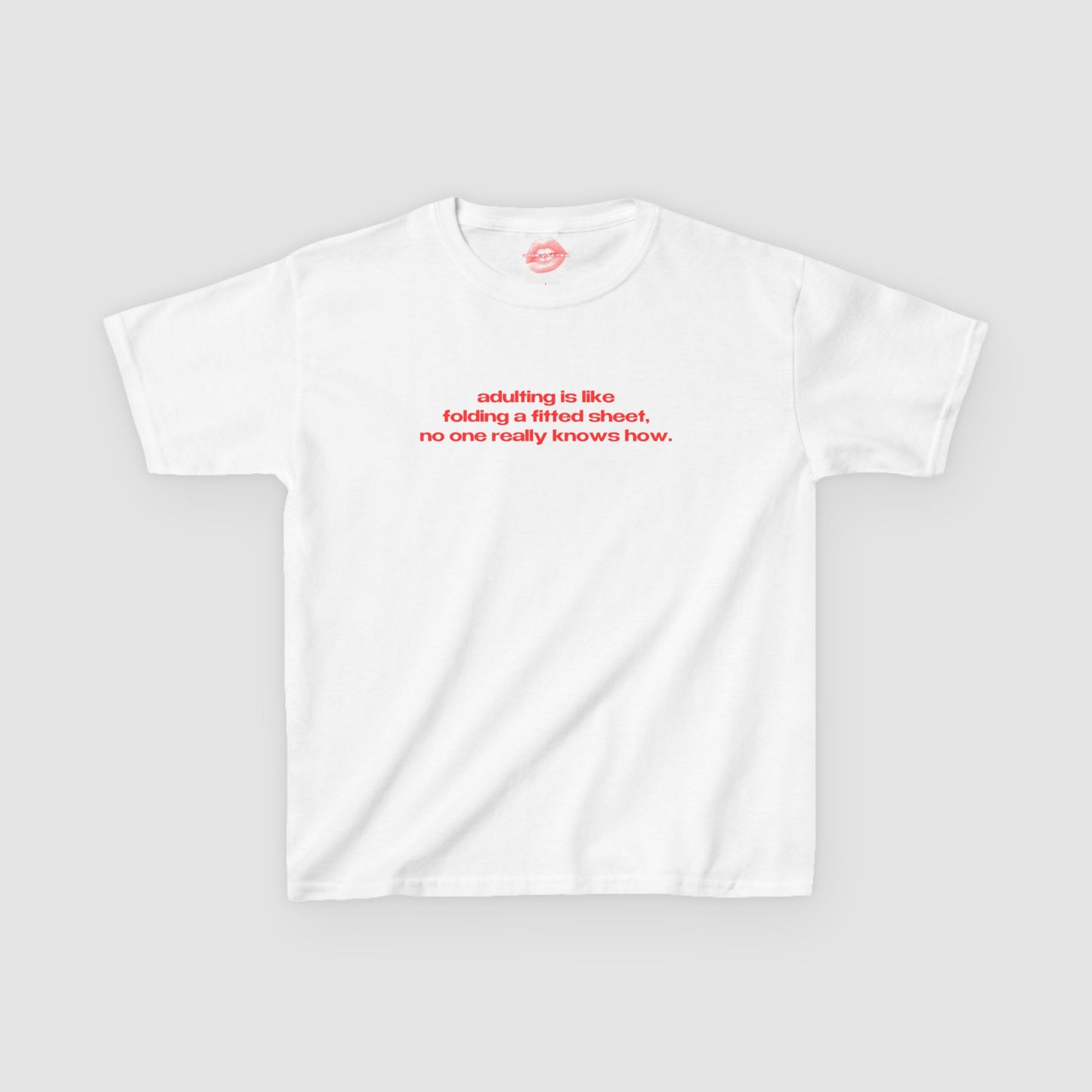 "Adulting Is Like Folding A Fitted Sheet, No One Really Knows How." | Text Only | Baby Tee