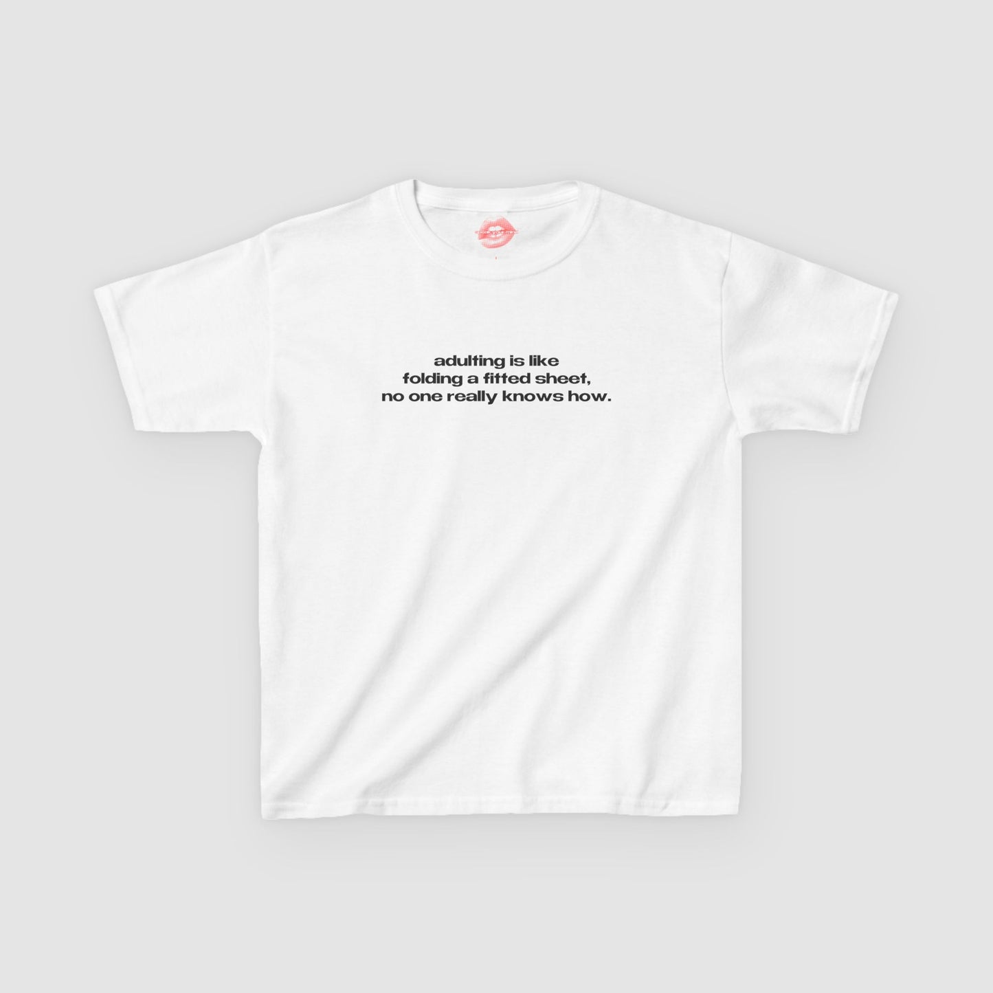 "Adulting Is Like Folding A Fitted Sheet, No One Really Knows How." | Text Only | Baby Tee